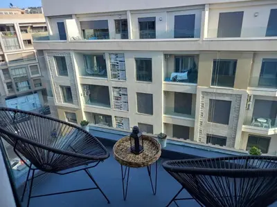 a balcony with two chairs and a table and a building at Elegance Comfort Terrace in the heart of Princesses in Maarif