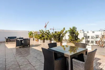 a patio with tables and chairs on a roof at Dynasty Estate Luxury Apartments in Palmiers, Casablanca in Maarif