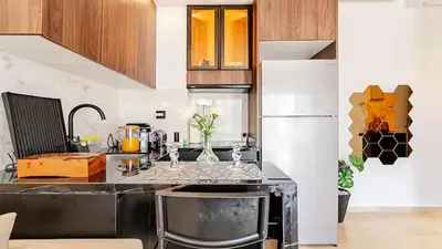 a kitchen with a black counter and a refrigerator at Dynasty Estate Luxury Apartments in Palmiers, Casablanca in Maarif
