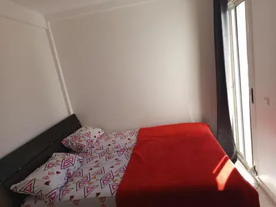 a small bedroom with a bed with a red blanket at Téranga imm in Casablanca