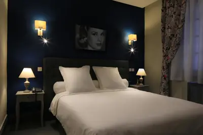 a bedroom with a large white bed with two lamps at Le Sphinx Boutique Hôtel in Mohammedia