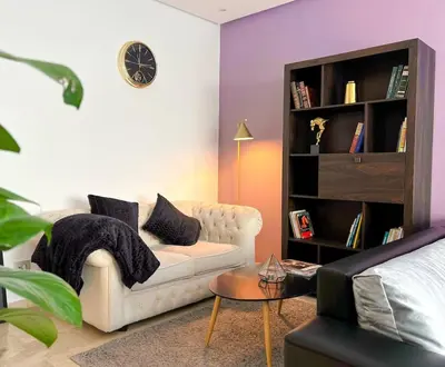 a living room with a white couch and a book shelf at Appartment 2 BR de luxe in Rabat