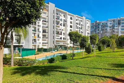a large apartment building with a swimming pool in a park at Appartment 2 BR de luxe in Rabat