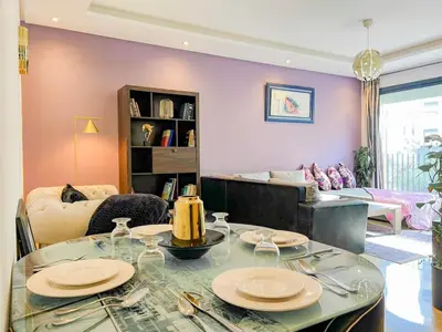 a living room with a table with plates on it at Appartment 2 BR de luxe in Rabat