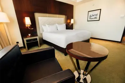 a hotel room with a large bed and a table at DoubleTree By Hilton Casablanca City Centre in Casablanca