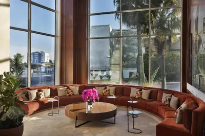 a living room with a couch and a table and windows at DoubleTree By Hilton Casablanca City Centre in Casablanca
