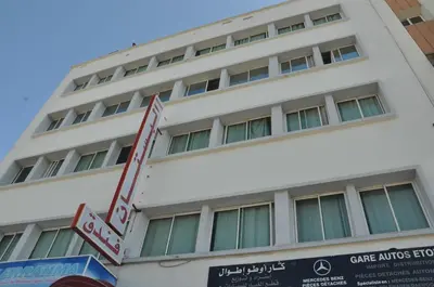 a white building with a sign in front of it at Hotel Boustane in Casablanca