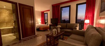 a living room with a couch and a bedroom at Soundouss Hotel in Rabat