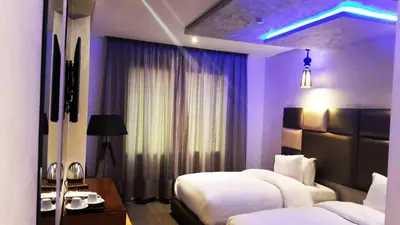 a hotel room with two beds and purple lighting at The Seven Hotel in Casablanca