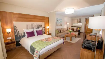 a bedroom with a large bed and a living room at Melliber Appart Hotel in Casablanca
