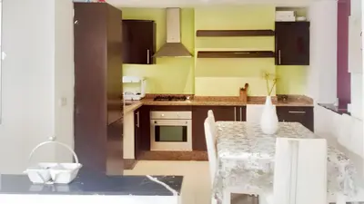 a kitchen with a table with a vase on it at Comfortable Apartment with Pool in Tamaris - 75 m² - Sea View in Dar Bouazza