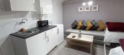 a small room with a sink and a couch at Studios Taha in Rabat
