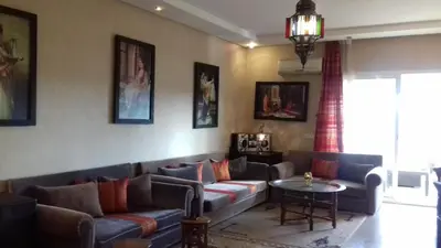 a living room with a couch and a table at Perle de Tamaris in Dar Bouazza