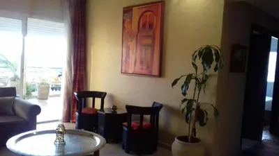 a living room with a table and a potted plant at Perle de Tamaris in Dar Bouazza