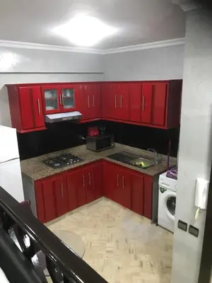 a kitchen with red cabinets and a white microwave at Casablanca centre ville in Casablanca