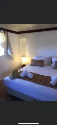 a hotel room with two beds and a lamp at Safa Boulaouane in Douar Annbirat