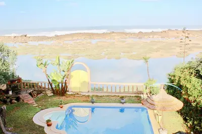 a swimming pool with a view of the beach at Aux Moules de Harhoura Rabat in El Harhoura