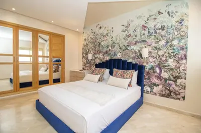 a bedroom with a large bed with a large painting on the wall at Luxe & sérénité près de l Aireport Mohamed 5, votre Havre de Paix in Nouaseur
