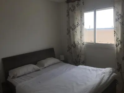 a bedroom with a large bed with a window at DaliMAR in Bouznika