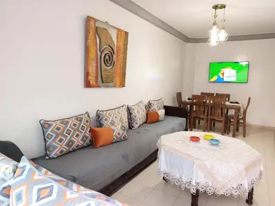 a living room with a couch and a table at Apartment in the city center, 2 minutes walk from the tram in Rabat