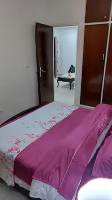 a bedroom with a large bed with a purple blanket at Apartment in the city center, 2 minutes walk from the tram in Rabat