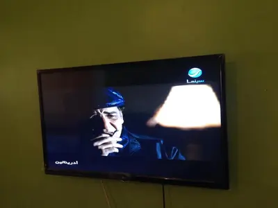 a television screen with a man wearing a hat at Agdal Two-Bedroom Apartment 2 Minutes from Agdal Train Station in Rabat