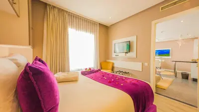 a bedroom with a large bed with purple pillows at RENT-INN Suites Hotel in Rabat