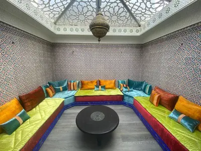 a living room with colorful couches and a table at Hotel Azur in Casablanca