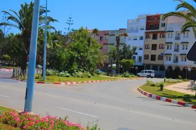 an empty street in a city with palm trees and buildings at Jnane Eddalya in Bouznika