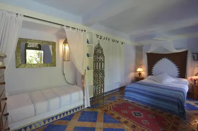 a bedroom with a bed and a mirror at Riad Des Plages in Bouznika