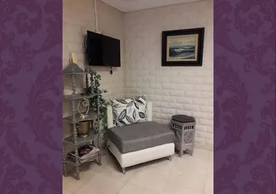 a living room with a chair and a tv at Studio les Belles Residences in Casablanca