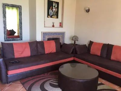 a living room with a couch and a table at Bouznika Charly's in Bouznika