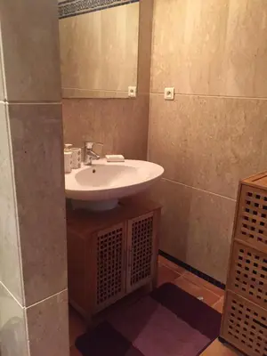 a bathroom with a sink and a mirror at Bouznika Charly's in Bouznika