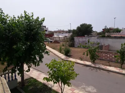 an empty street in a city with trees and buildings at Villa Close To The Beach in Temara