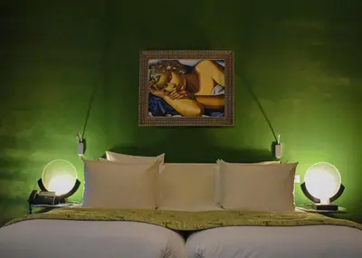 a bedroom with a green wall with a bed and two lamps at Hôtel particulier Le DOGE - Relais & Châteaux in Casablanca