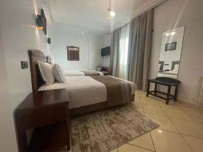 a hotel room with a bed and a table at Hôtel Amouday in Casablanca