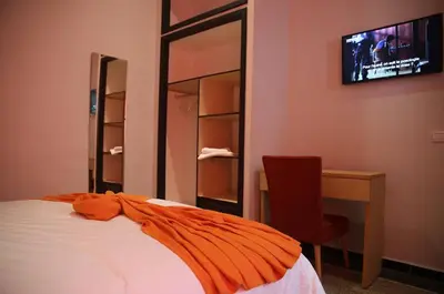 a bedroom with a bed and a desk and a television at Point du Jour in Casablanca