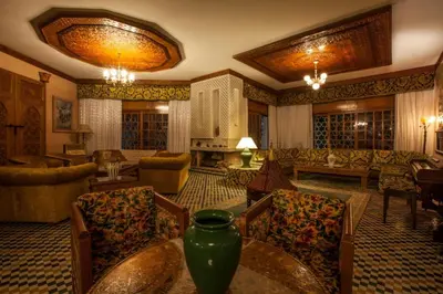 a large living room with a table and chairs at Riad Alhambra in El Harhoura
