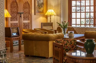 a living room with a couch and chairs and a television at Riad Alhambra in El Harhoura