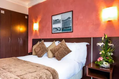 a hotel room with a bed and a red wall at Relax Hotel Airport Nouasseur in Nouaseur