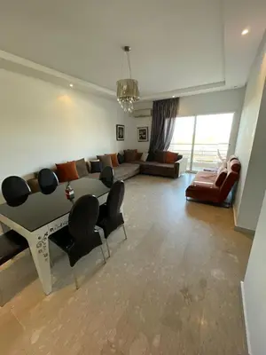 a living room with a couch and a table and chairs at Les perles de tamaris dar bouazza in Dar Mohammed Ould Haj Jilali