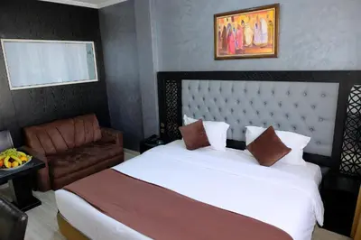 a bedroom with a large white bed and a chair at Washington Hotel in Casablanca