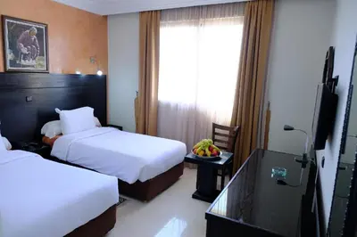 a hotel room with two beds and a television at Washington Hotel in Casablanca