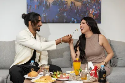 a man feeding a woman eating food on a couch at Oum Palace Hotel & Spa in Casablanca