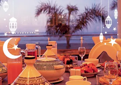 a table with plates of food and wine glasses at Avanti Mohammedia Hotel in Mohammedia