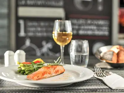 a plate of food and a glass of wine on a table at Ibis Casa Voyageurs in Casablanca