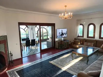 a living room with a couch and a table at Villa meublée face à la mer, Golf et Verdure in El Jadida