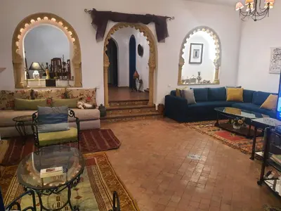 a living room with a couch and a table at Villa à Bouznika Bay-plage et golf in Bouznika
