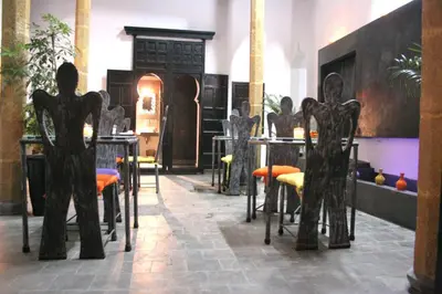 a room with tables and chairs with statues in it at Riad7 in Azemmour