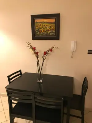 a black table with a vase with flowers on it at Résidence les Ambassadeurs in Rabat